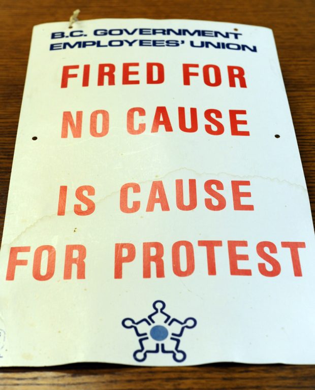 A strike placard reads “BC Government Employees’ Union, Fired for No Cause is Cause for Protest” and includes the logo of the BCGEU.