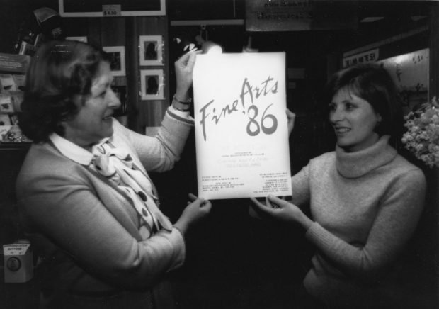 Two women holding up a poster for the Sooke Fine Arts Show of 1986.