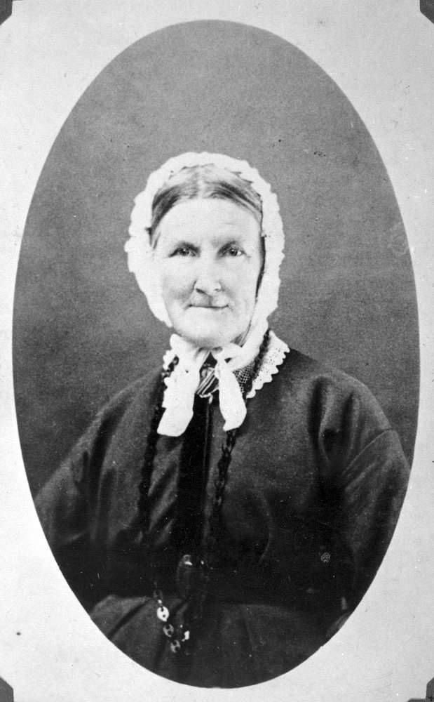 A black and white portrait photo of a woman with a white bonnet.