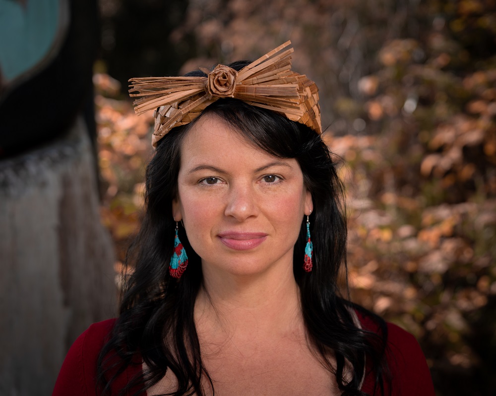 Portrait photo of a woman wearing a traditional woven cedar headband.