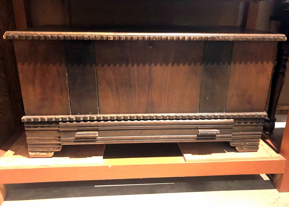 A large cedar wood chest in a museum display.