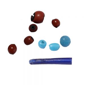 One long dark blue tube bead with three circular light blue beads. Five reddish circular beads with black interiors.