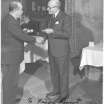 Gerald Bruck congratulates an employee