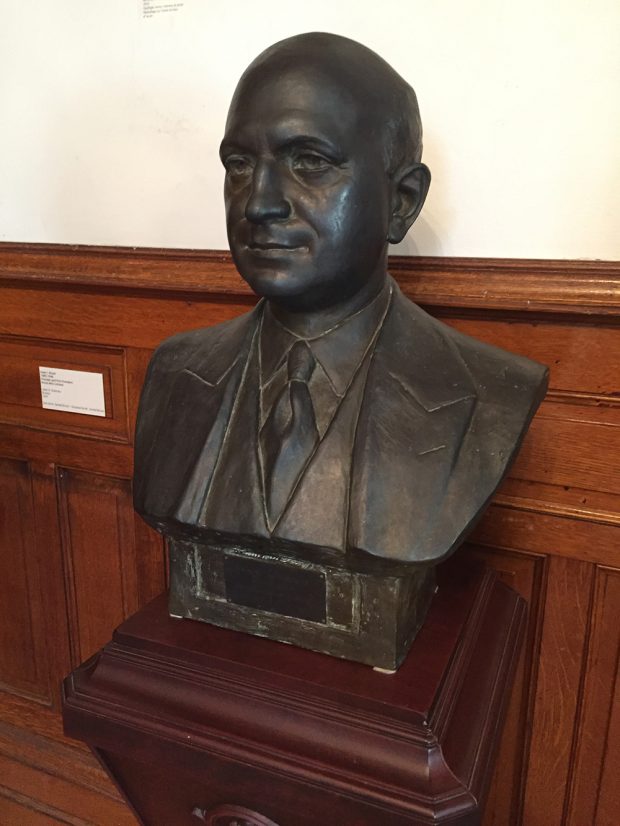 A cast bronze bust of Isaac Bruck placed on a pedestal