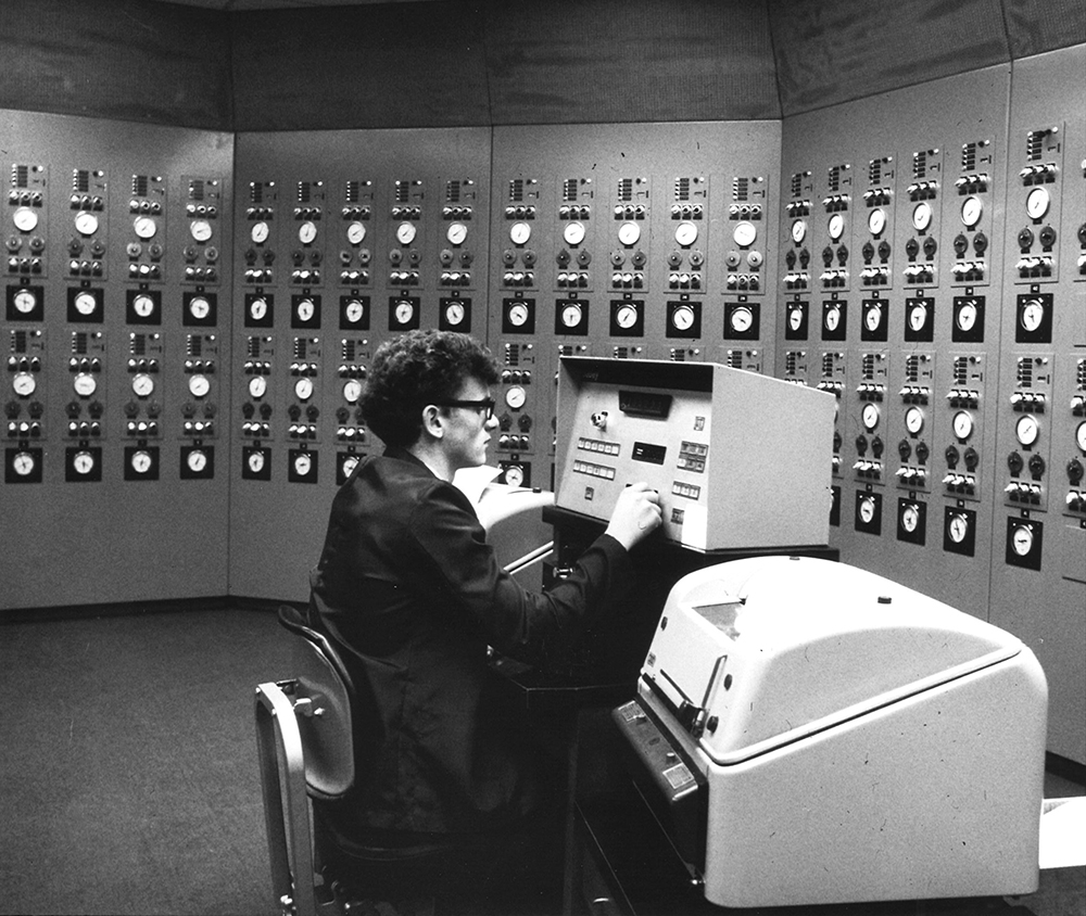 An employee sits at his workstation in a computer control room