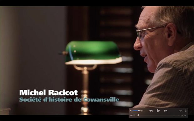Profile of a man (Michel Racicot) staring straight ahead with a green table lamp beside him.