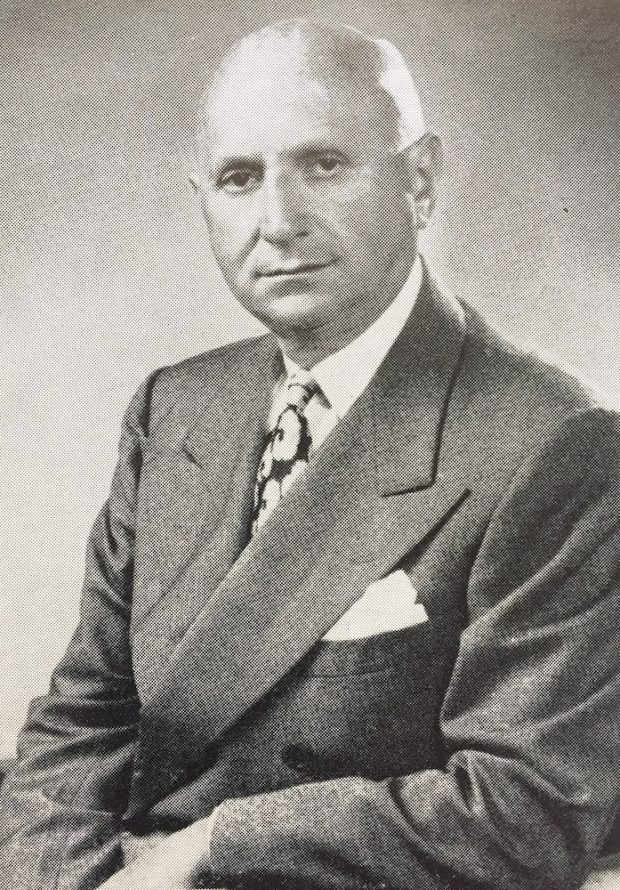Formal black and white portrait of Isaac Bruck, in suit and tie