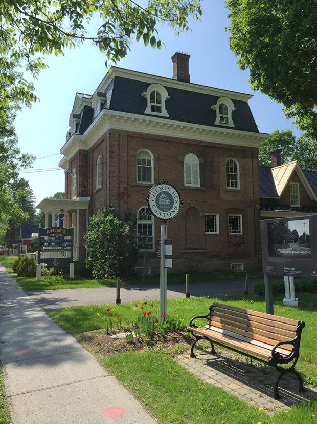 Photo of the Bruck Museum with park bench and sign in the foreground