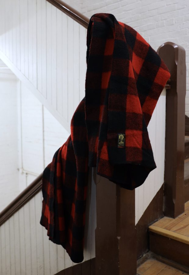 A red and black plaid blanket draped over a stairwell