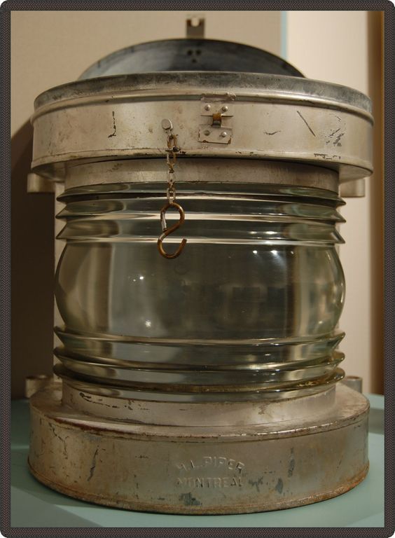 Cylinder-shaped metal and glass lamp with H.L. Piper Montreal engraved on its stand.