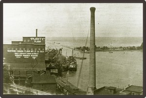 Black and white photo of a harbour and a factory