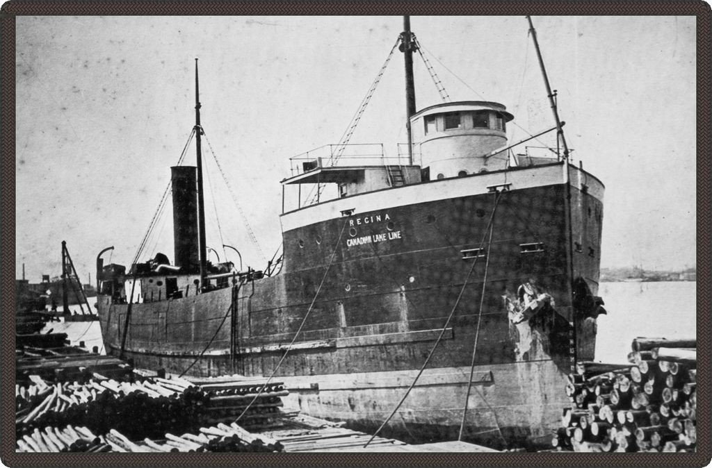 Photo en noir et blanc d’un bateau accosté dans un port