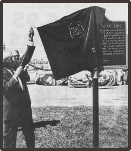 Black and white photo of a man unveiling a plaque.