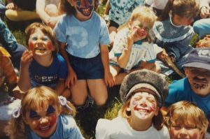 Colour photo of smiling children with face paint.