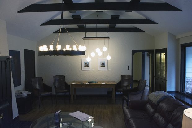 Colour photograph of of a living room with high peaked ceiling and furniture.