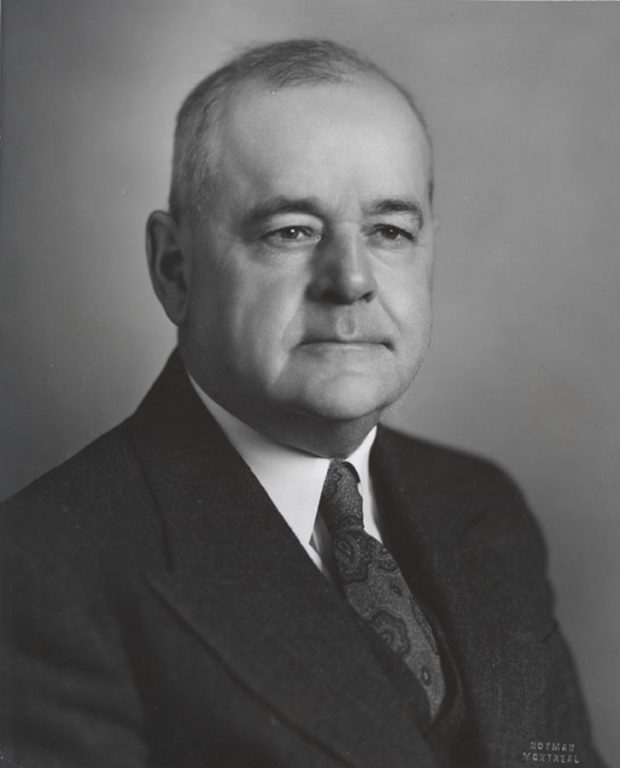 Black & white photograph of a man wearing a suit and tie.