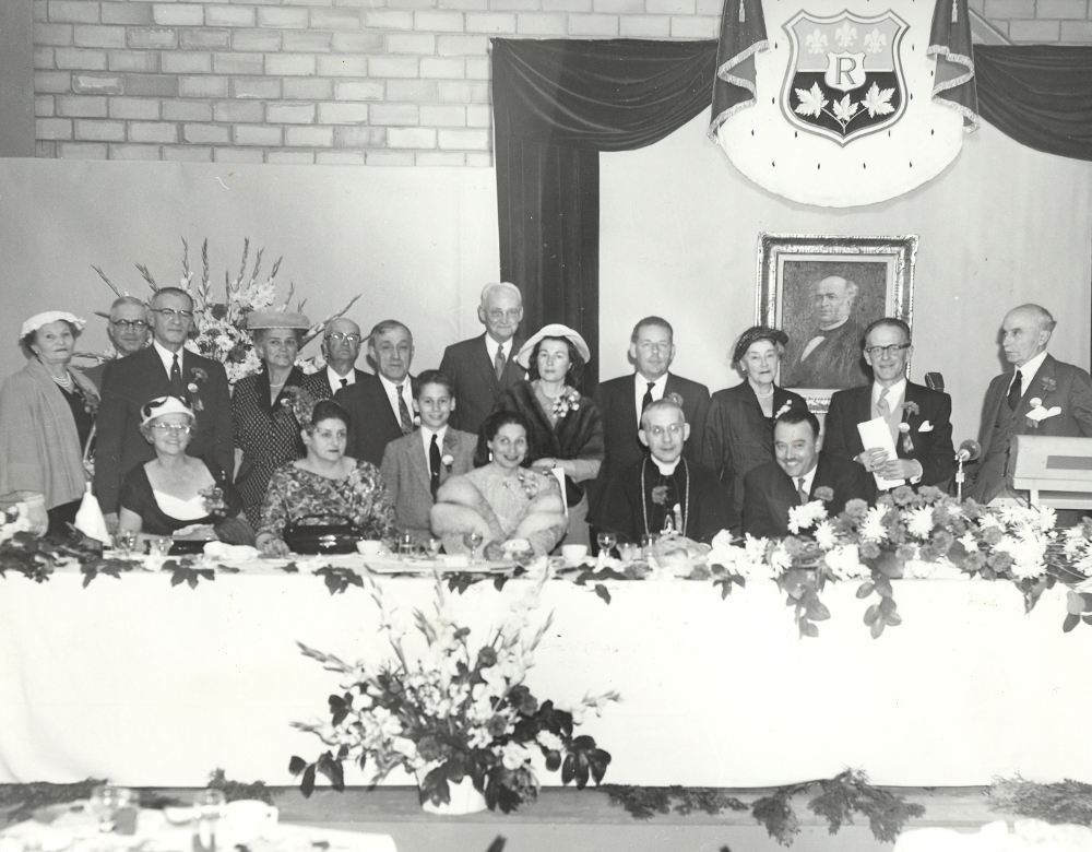 Black & white photograph of a head table group at a celebration.