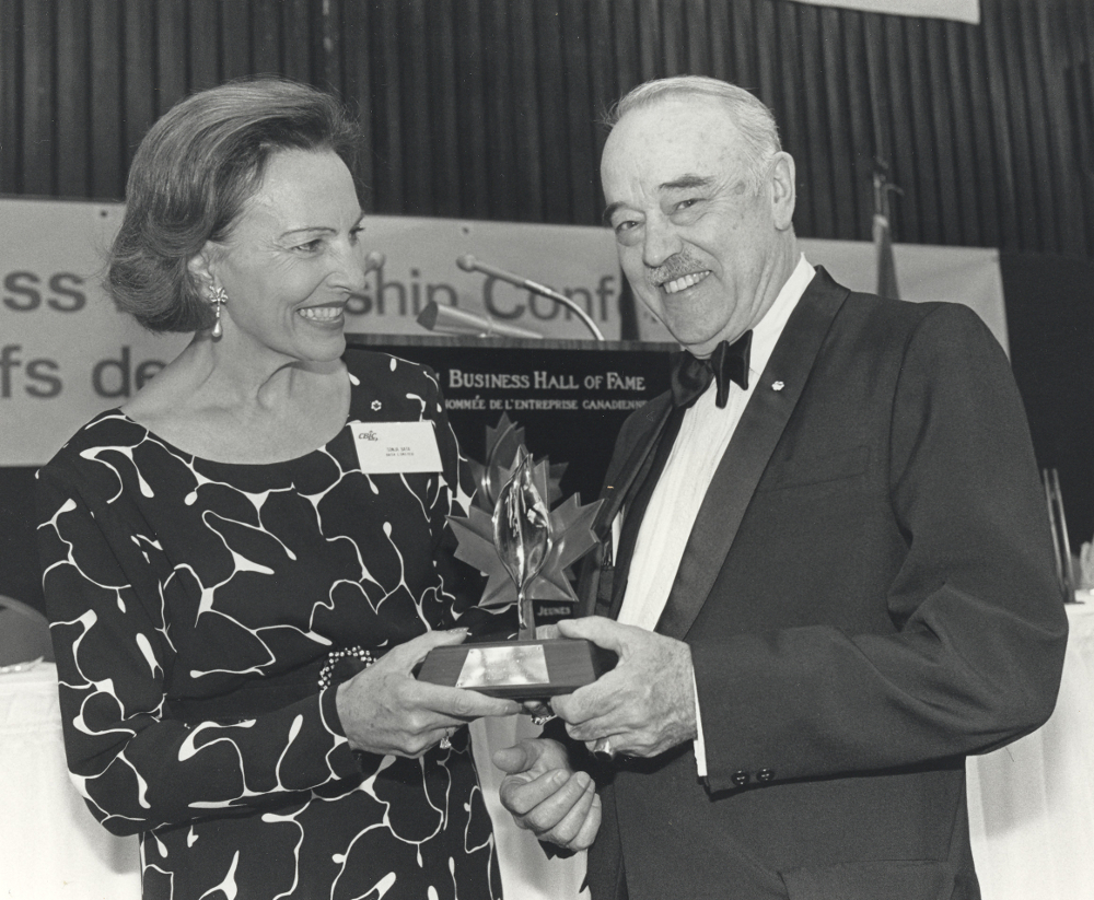 Black & white photograph of a man and woman holding a trophy.