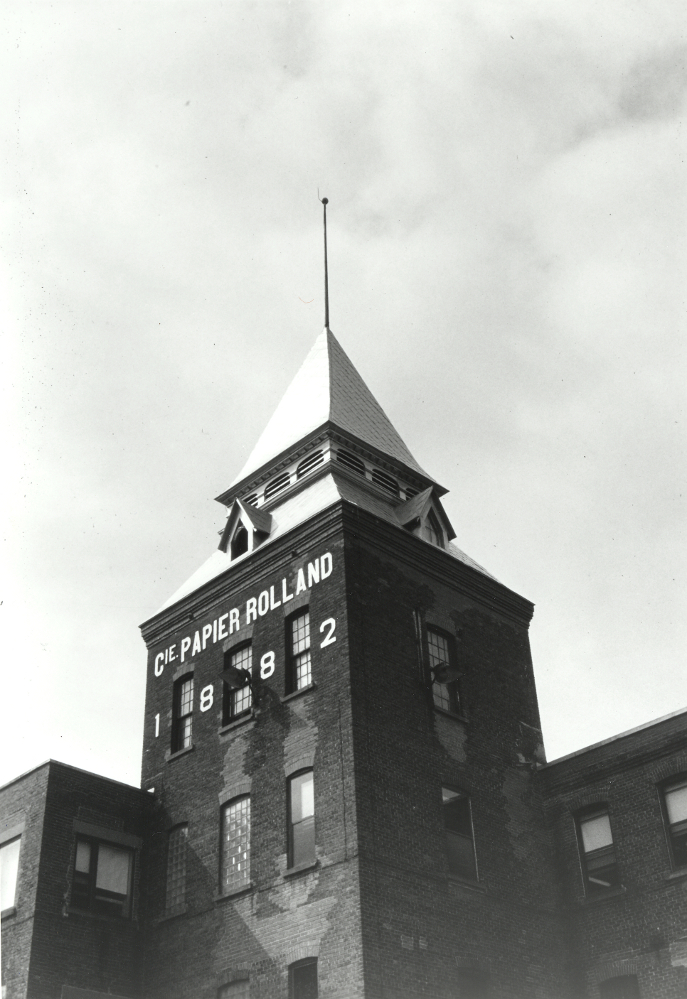 Black & white photograph showing a tower above a building.