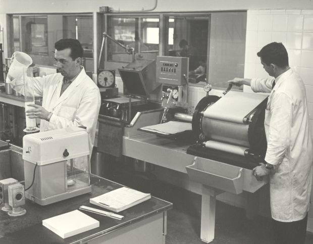 Black & white photograph showing two men in white coats in a laboratory.
