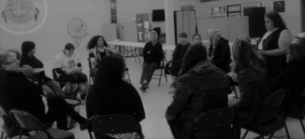 A group of women sit on chairs in a circle.