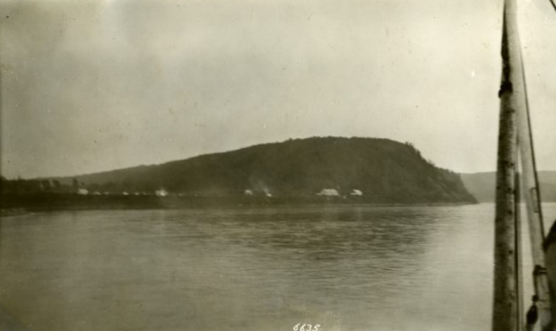 Black and white photo of a hilly land across a body of water.