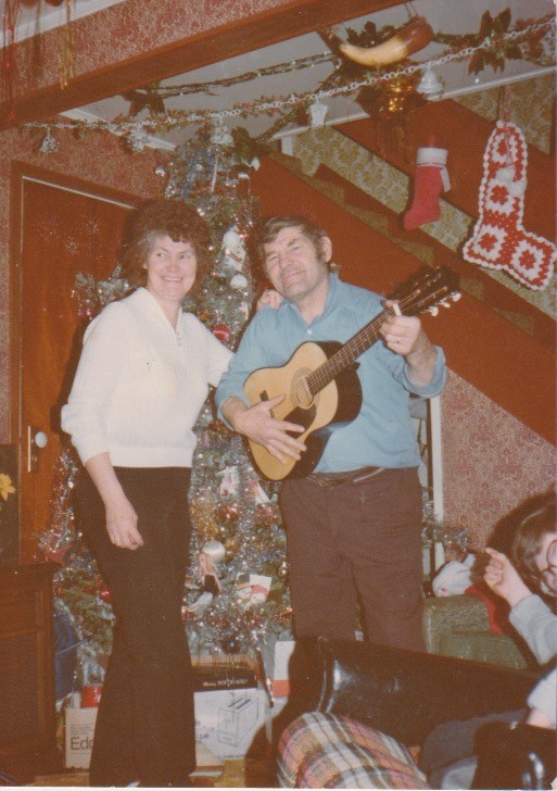 A man plays guitar while a woman sings