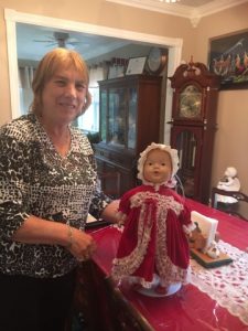 Ann Murphy with a doll in a red dress. She received this doll over 70 Christmases ago