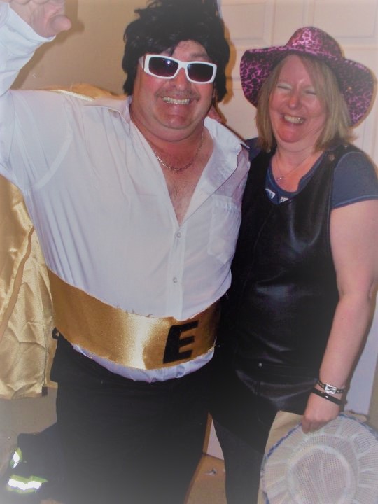 A man dressed as Elvis and a woman prepare for a concert