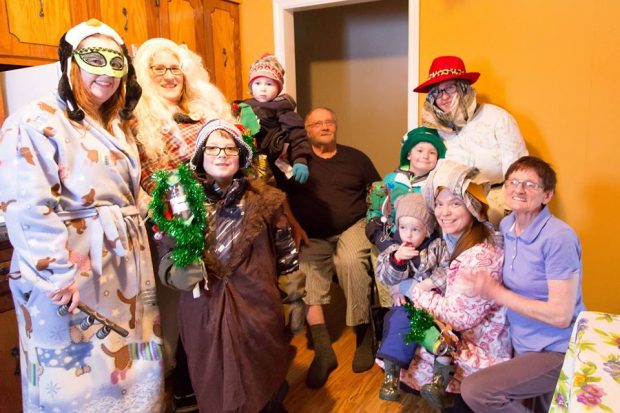 a group of adults and children dressed as Mummers visit a home