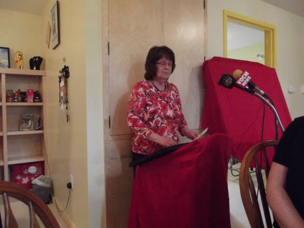 A woman speaks from behind a podium