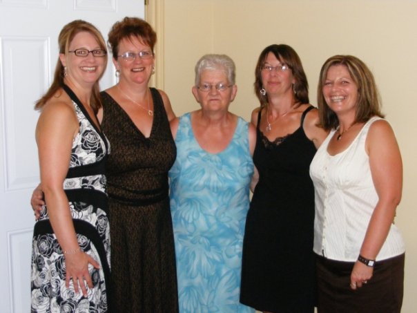 A woman and her four daughters dressed for a formal occasion