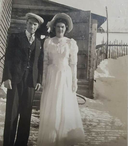 bride and groom pose for photo outside in the snow