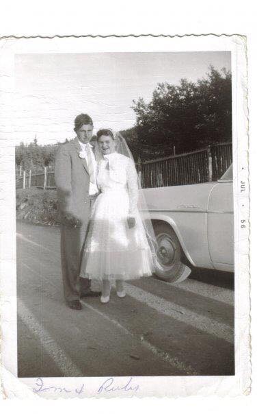 Bride and groom stand next to a white truck