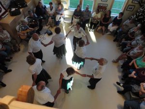 A group of men and women of the Little Bay heritage dancers performing a square dance