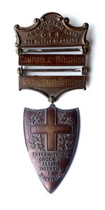 A medal in a shield shape, obverse only. There is a cross and maple leaves and writings; the shield is suspended to a ribbon through a bar reading ARCHIBALD BECHER. A second bar is added and reads "Campbell Becher."