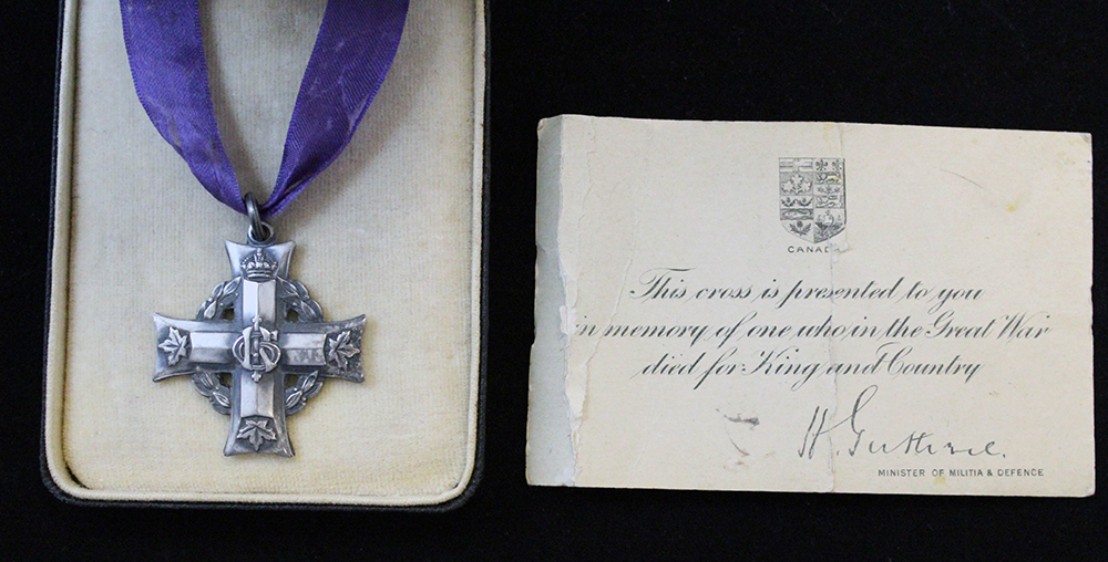 A box with a silver cross suspended to a purple ribbon and a card signed by the Minister of Militia and Defence.