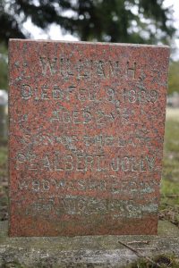 Une pierre tombale avec des noms et des dates gravés dessus.