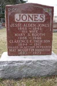 A rectangular grave stone with little ornament and the word JONES carved in.