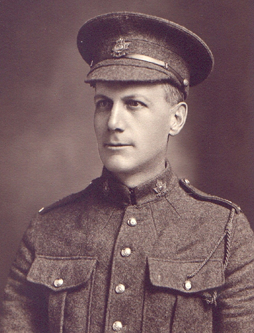 Portrait of a soldier wearing a peak hat. Chest pockets, buttons and collar dogs can be seen.