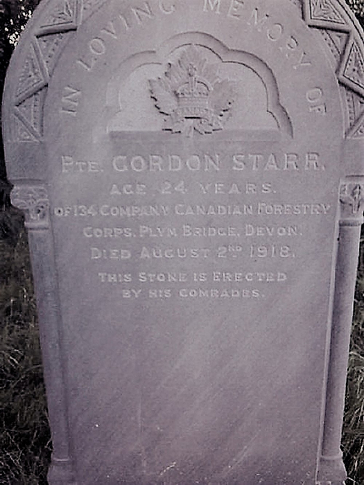 A stone grave semicircular at the top, with decorations and a maple leaf and a crown in the centre of the semicircle.