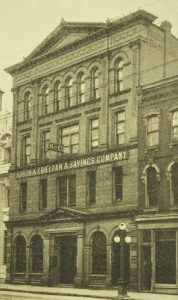 Une photo montrant un bâtiment à quatre étages et l’enseigne « Huron & Erie Loan & Savings Company ».