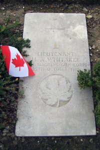 Une pierre tombale avec une coix et une feuille d'érable. On voit l'étandard du Canada.