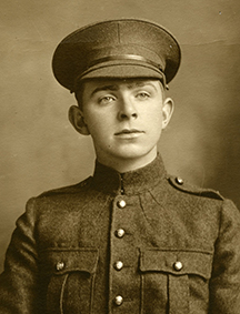 Portrait of a soldier wearing a peak hat. Chest pockets and buttons can be seen.