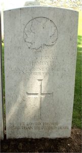 Une pierre tombale sur laquelle sont gravées une feuille d’érable et une croix.
