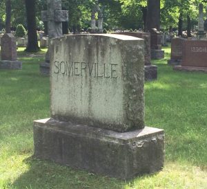 Photograph of a headstone in a cemetery. The name "SOMERVILLE is carved on it.