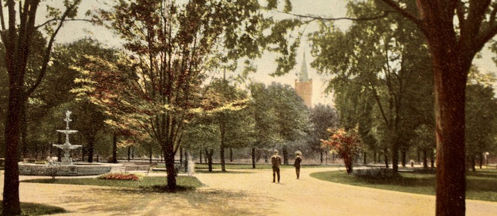 Post card of a park. A fountain can be seen at the left and the tower of a church in the background. The inscription View of Victoria park, London, Ont. on the lower right.