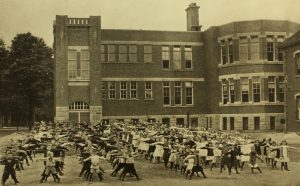 Photograph of a building and children exercising.