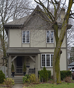 The front of a two story house with a tree.