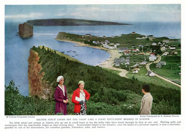 The photograph was taken from a point of view that allows us to see the village of Percé in the 1930s and the dirt road leading to it. There are some boats near the shoreline and in the distance the Percé Rock and Bonaventure Island. In the foreground, two women look in our direction and a third person admires the landscape.